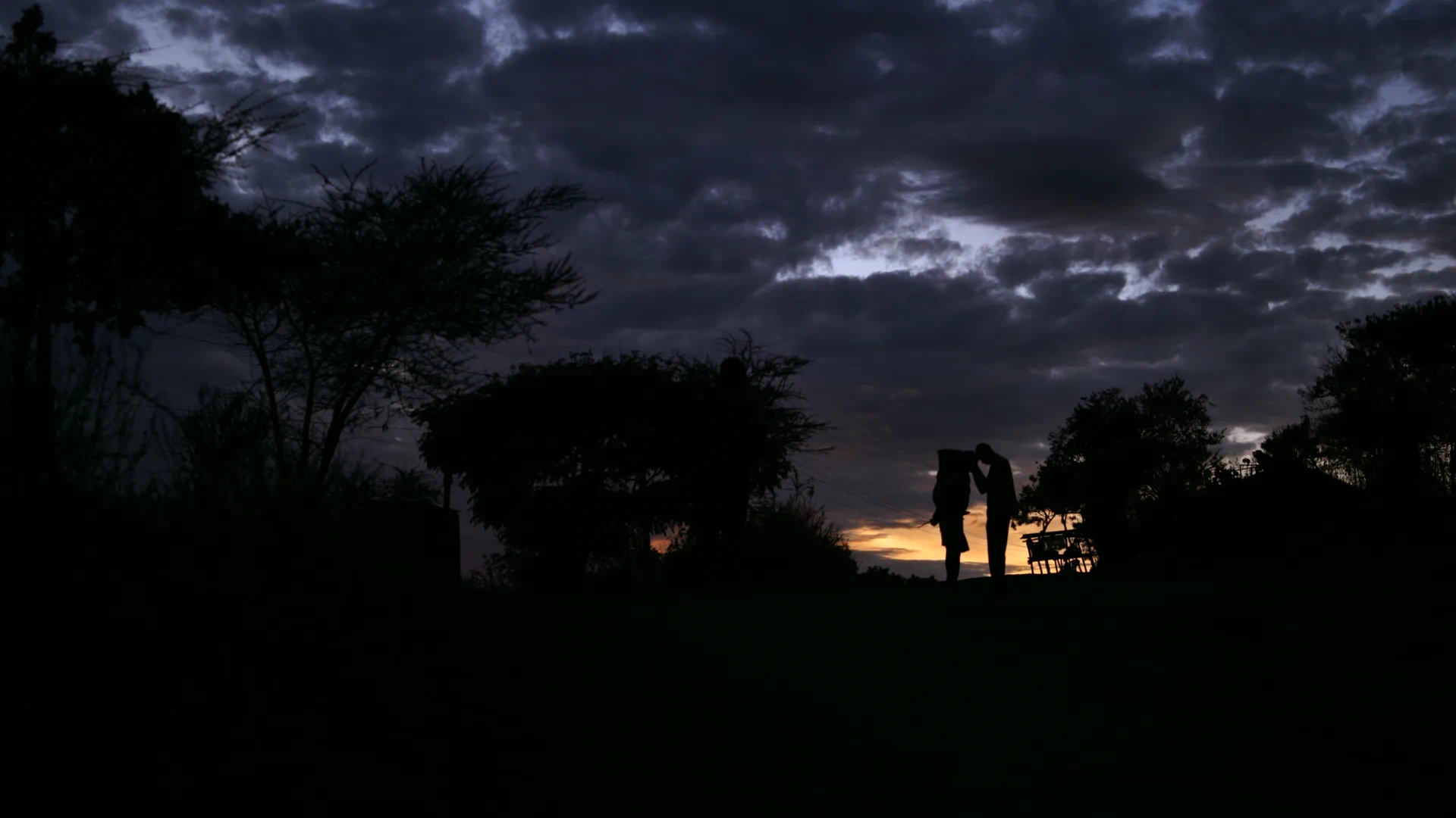A sunset scene with a fisherman and young woman in an island of the Lake Victoria, Kenya